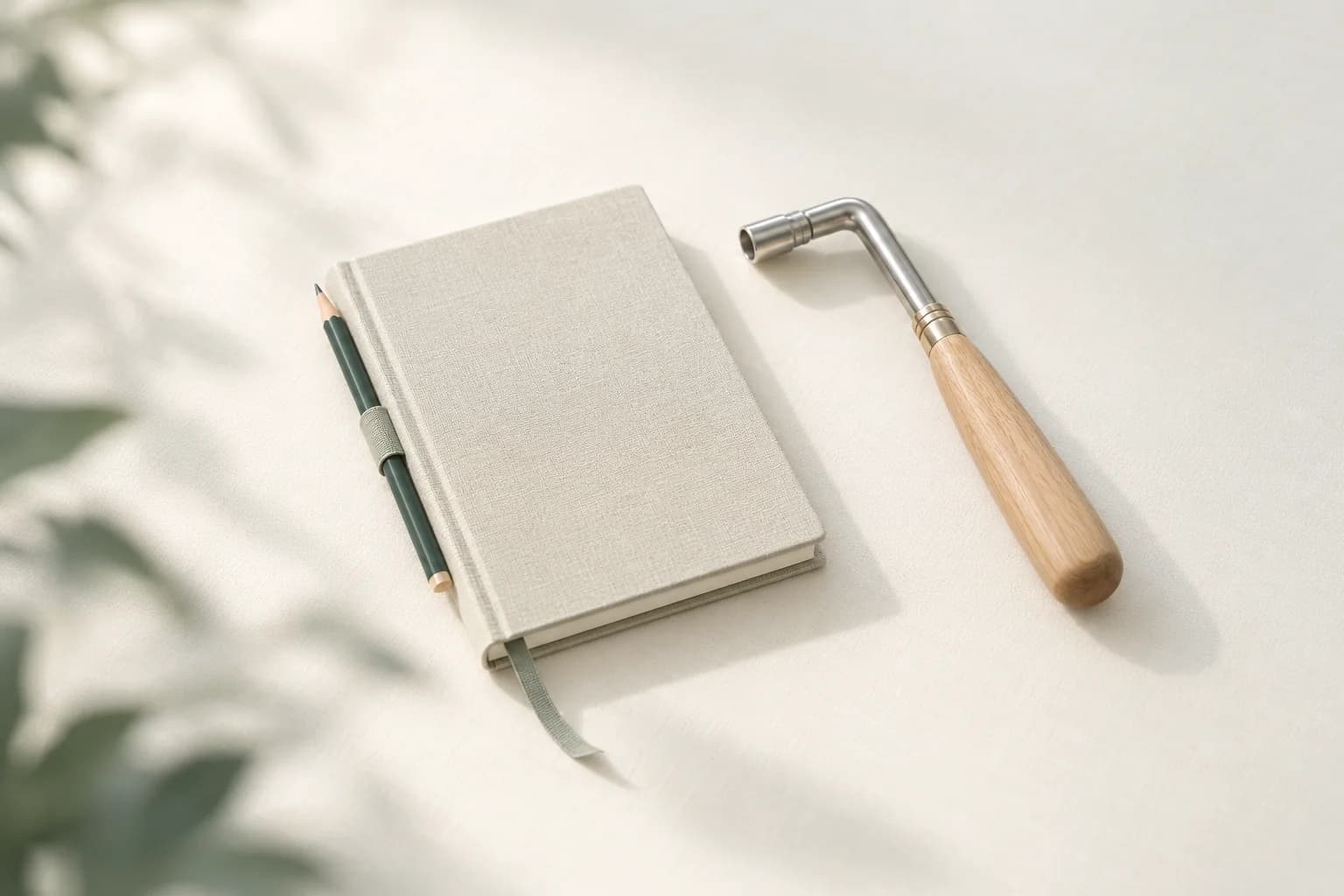 Illustration: gebundenes Notizheft mit eingestecktem Bleistift und Lesebändchen, daneben ein Stimmhammer für Klaviere mit Holzgriff