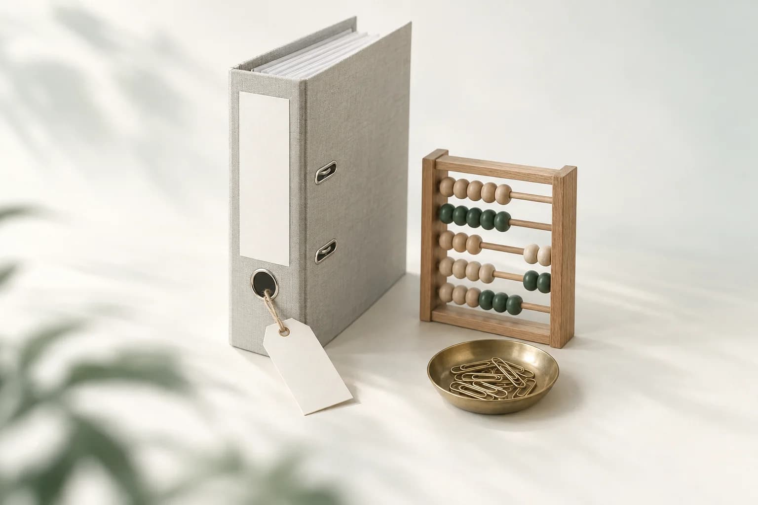 Illustration: dicker Ordner mit leerem Preisschild an einer Schnur, daneben ein kleiner Abakus und eine Messingschale mit Büroklammern