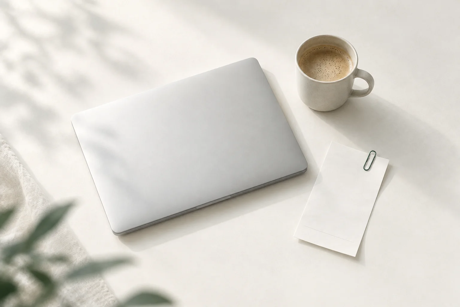 Illustration: zugeklapptes silbernes Notebook, daneben eine Tasse Kaffee und ein leerer Kassenbon mit Büroklammer
